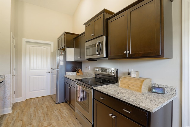 kitchen featuring light hardwood / wood-style floors, light stone counters, dark brown cabinetry, and appliances with stainless steel finishes