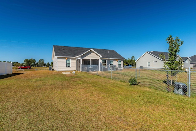 rear view of house featuring a yard and central AC unit