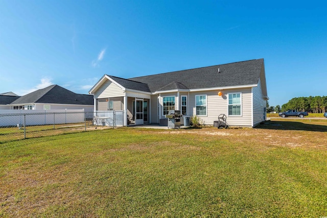 rear view of house with a lawn and a patio area