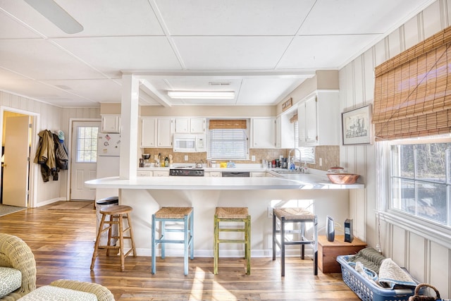 kitchen with white cabinets, white appliances, a paneled ceiling, and sink