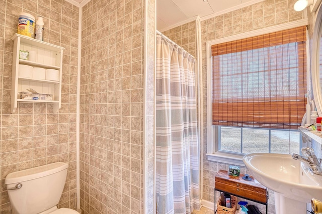 bathroom featuring toilet, sink, crown molding, and tile walls