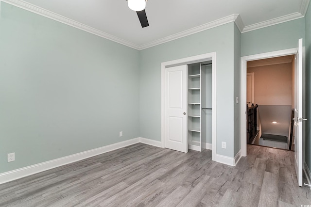 unfurnished bedroom featuring crown molding, light hardwood / wood-style flooring, a closet, and ceiling fan