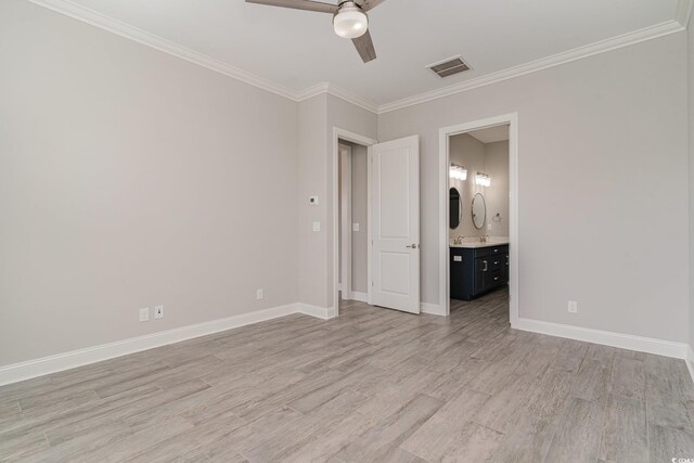 unfurnished bedroom featuring ornamental molding, ensuite bathroom, light wood-type flooring, and ceiling fan