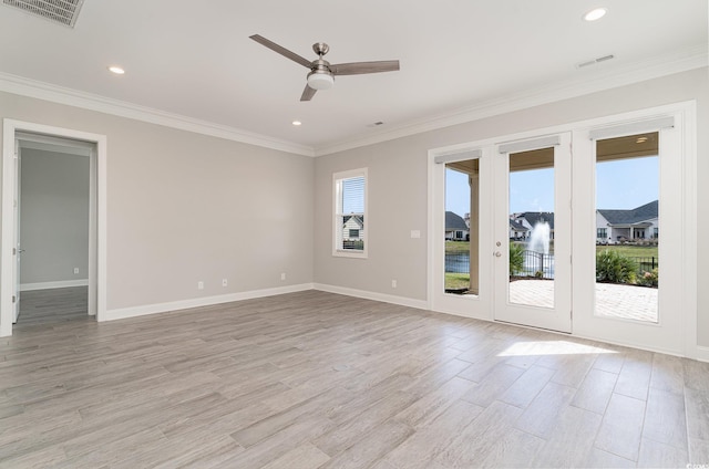 empty room featuring light wood-type flooring, crown molding, and plenty of natural light