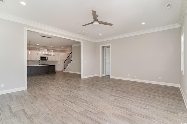 unfurnished living room with sink, crown molding, light wood-type flooring, and ceiling fan