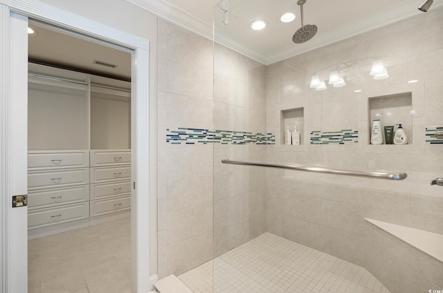 bathroom featuring ornamental molding, tile patterned flooring, and tiled shower