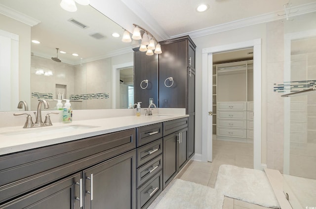 bathroom featuring vanity, crown molding, a tile shower, and tile patterned floors