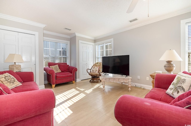 living room featuring ornamental molding, light hardwood / wood-style flooring, ceiling fan, and plenty of natural light