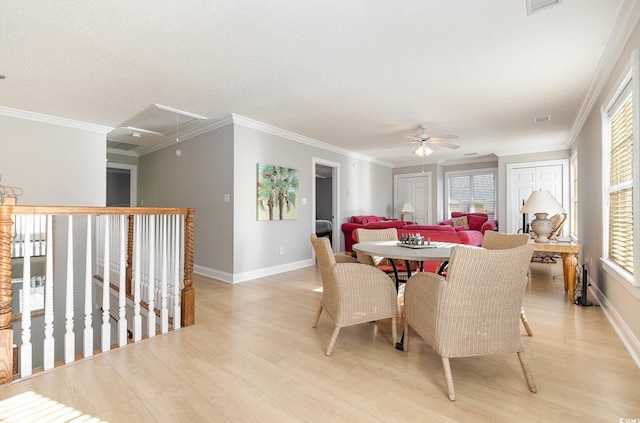 dining space featuring crown molding, a textured ceiling, light wood-type flooring, and ceiling fan