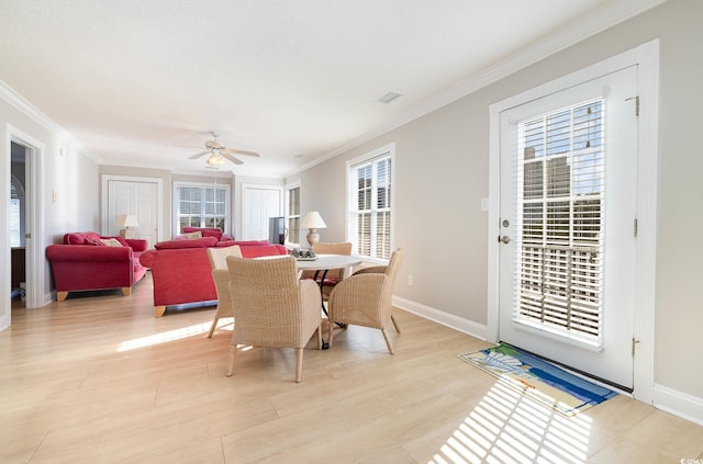 dining room with ornamental molding, ceiling fan, light wood-type flooring, and a wealth of natural light