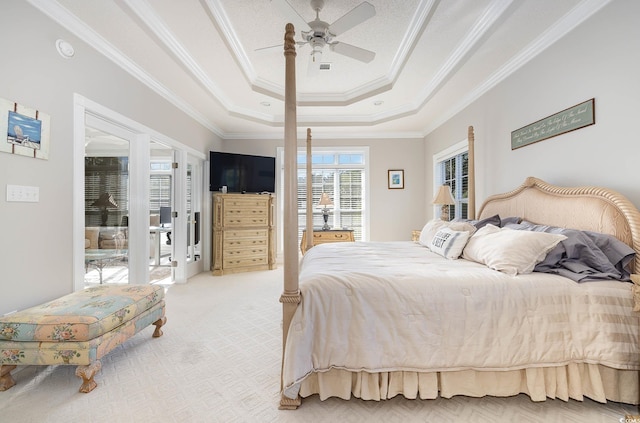 carpeted bedroom with ceiling fan, crown molding, access to outside, and a tray ceiling