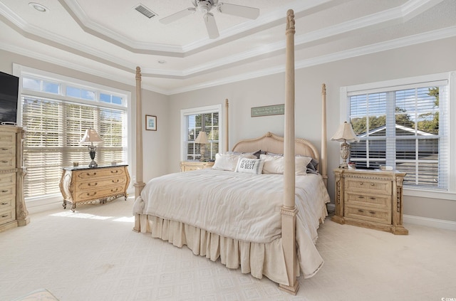 bedroom featuring multiple windows, ornamental molding, a raised ceiling, and ceiling fan