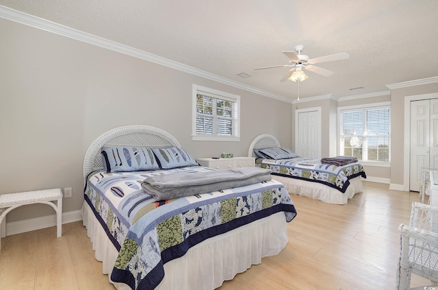 bedroom with light hardwood / wood-style floors, crown molding, a textured ceiling, and ceiling fan