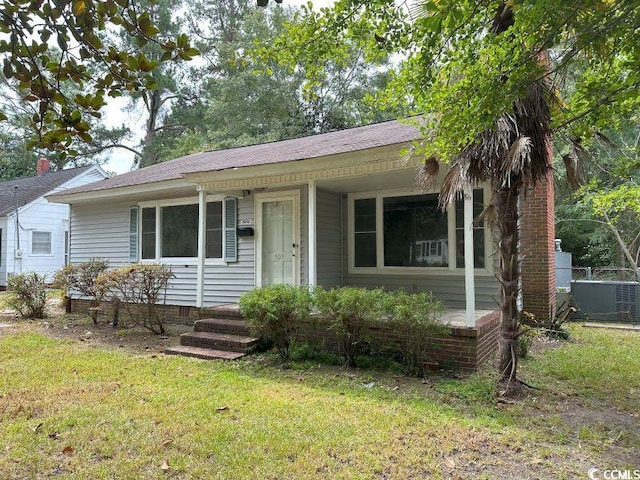 ranch-style home with cooling unit and a front yard