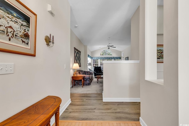 corridor with lofted ceiling and light wood-type flooring