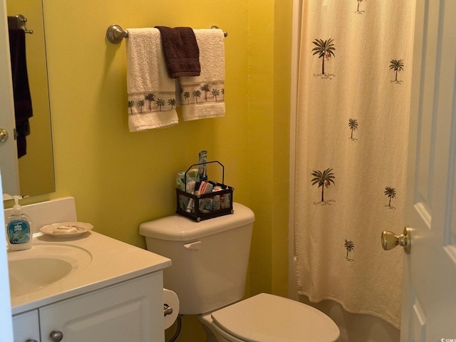 bathroom featuring vanity, walk in shower, and toilet