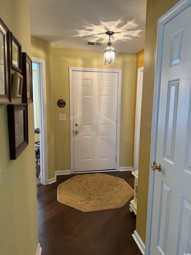 entryway featuring a textured ceiling and dark hardwood / wood-style floors