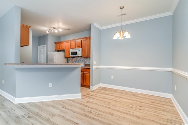 kitchen with light wood finished floors, visible vents, backsplash, white appliances, and brown cabinetry