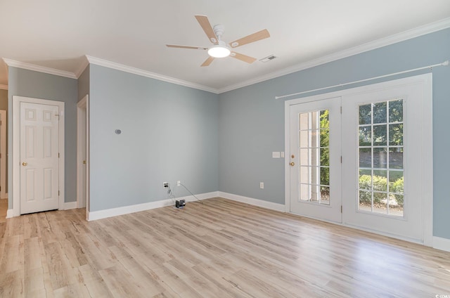 spare room with baseboards, ornamental molding, light wood-style floors, and visible vents