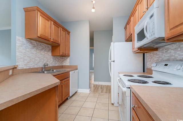 kitchen featuring sink, decorative backsplash, white appliances, and light tile patterned floors