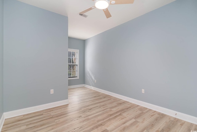 unfurnished room with baseboards, a ceiling fan, wood finished floors, and visible vents