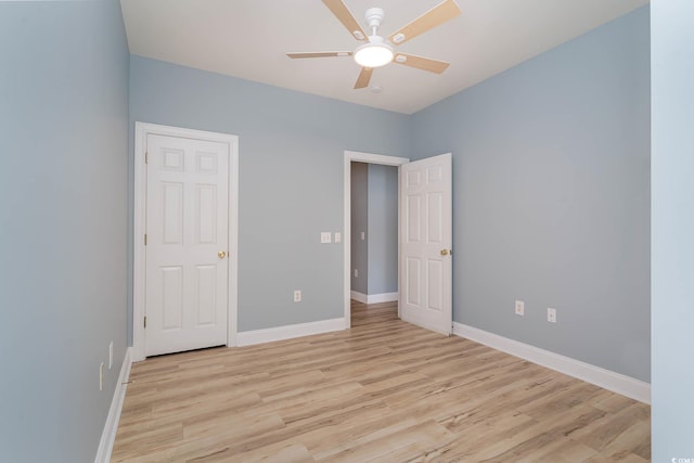 unfurnished bedroom featuring light wood-style flooring, baseboards, and a ceiling fan