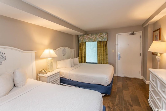bedroom featuring baseboards and dark wood-style flooring