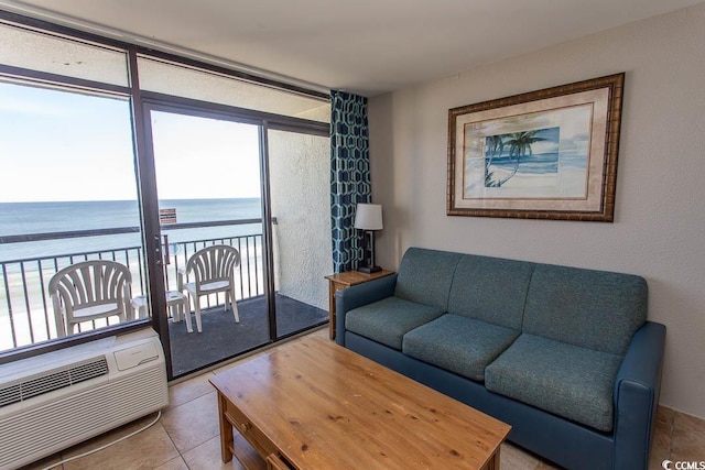 living room with a wall mounted AC, light tile patterned flooring, and a water view