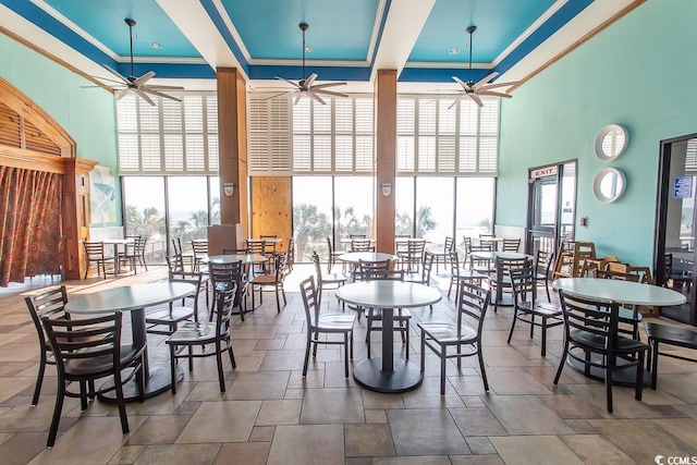 dining area with ornamental molding, a high ceiling, and ceiling fan