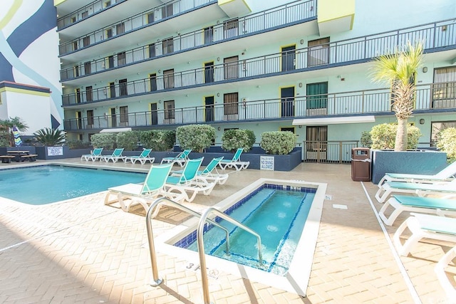 pool featuring a community hot tub and a patio area