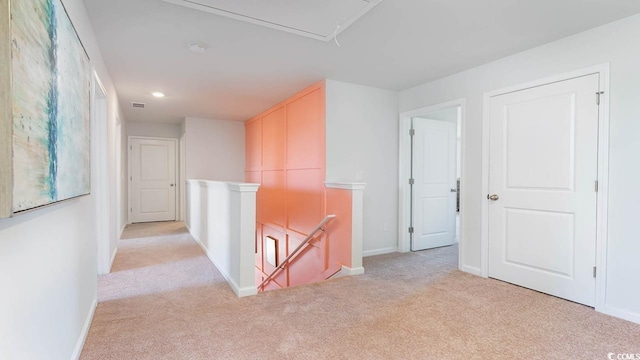 hallway featuring light colored carpet