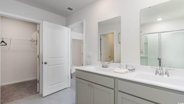 bathroom featuring vanity, tile patterned floors, and a shower with shower door