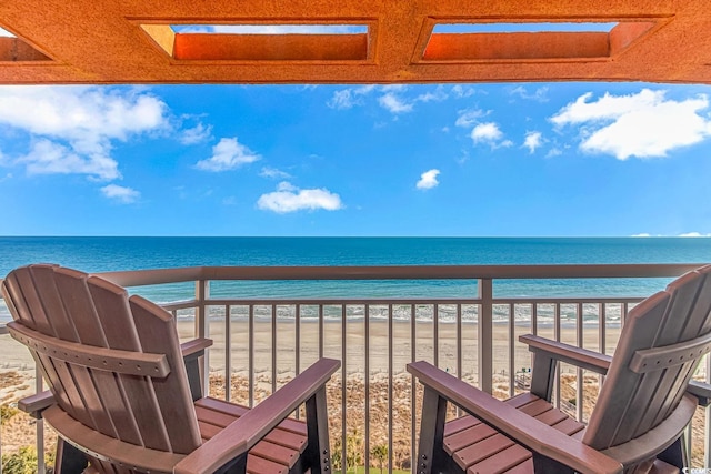 balcony featuring a view of the beach and a water view