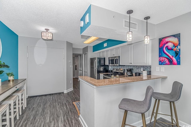 5300 N Ocean Blvd Unit 1405, Myrtle Beach, SC 29577 - kitchen with decorative backsplash, appliances with stainless steel finishes, dark wood-style flooring, visible vents, and a textured ceiling