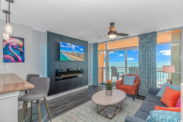 5300 N Ocean Blvd Unit 1405, Myrtle Beach, SC 29577 - living area with a textured ceiling, wood finished floors, a glass covered fireplace, and a ceiling fan