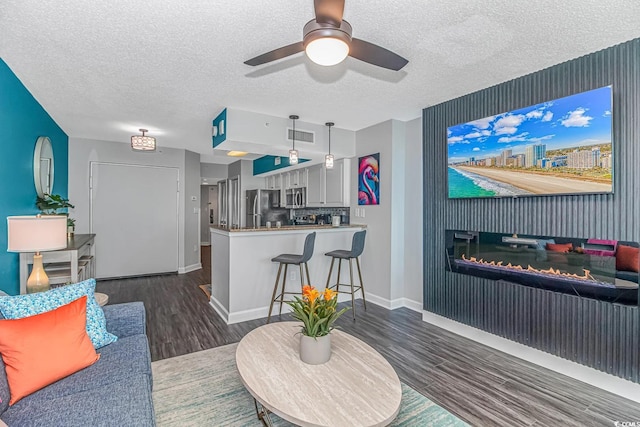 5300 N Ocean Blvd Unit 1405, Myrtle Beach, SC 29577 - living room with a textured ceiling, ceiling fan, visible vents, baseboards, and wood finished floors