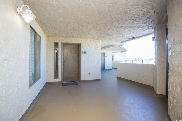 interior space with a textured ceiling and concrete flooring