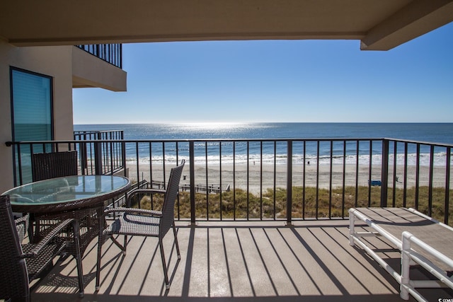 balcony featuring a water view and a beach view