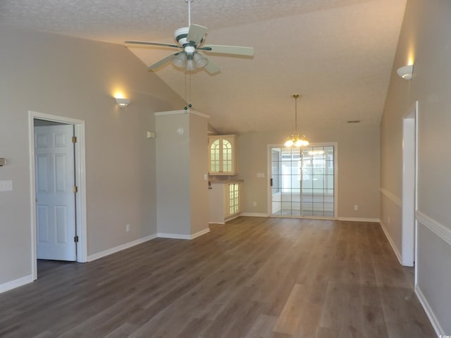 unfurnished living room featuring a textured ceiling, dark wood-type flooring, ceiling fan with notable chandelier, and vaulted ceiling