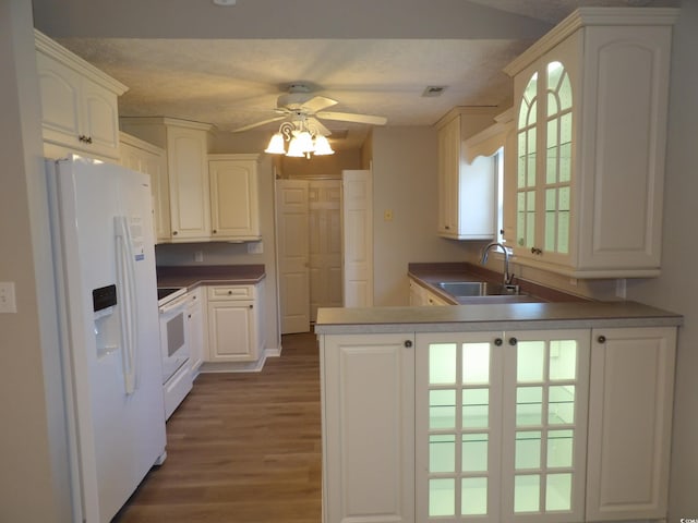 kitchen with kitchen peninsula, sink, plenty of natural light, and white appliances