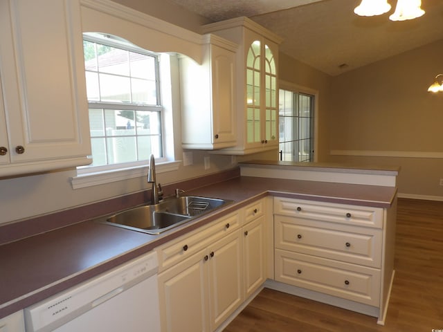 kitchen with dark hardwood / wood-style flooring, kitchen peninsula, dishwasher, and a wealth of natural light