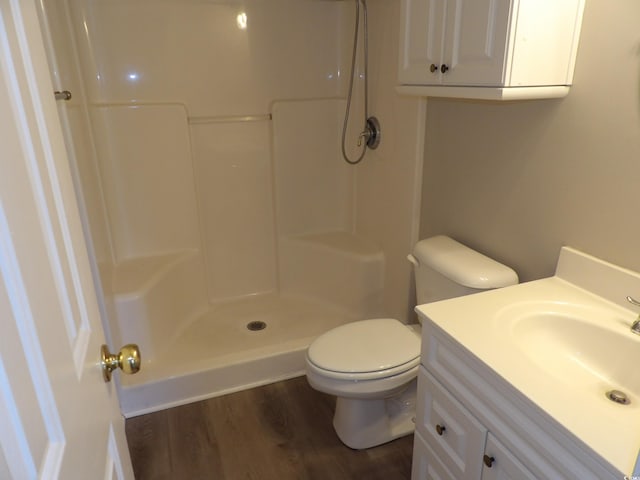 bathroom with vanity, a shower, hardwood / wood-style flooring, and toilet