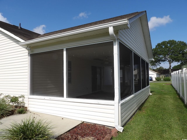 view of home's exterior with a yard and a sunroom