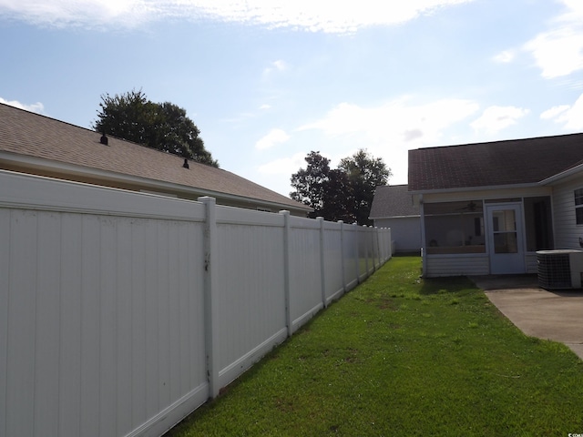 view of yard featuring central air condition unit and a sunroom