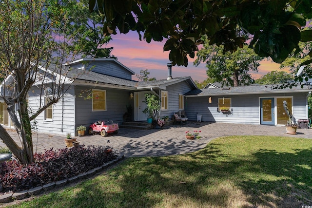 view of front of house with a patio area and a lawn