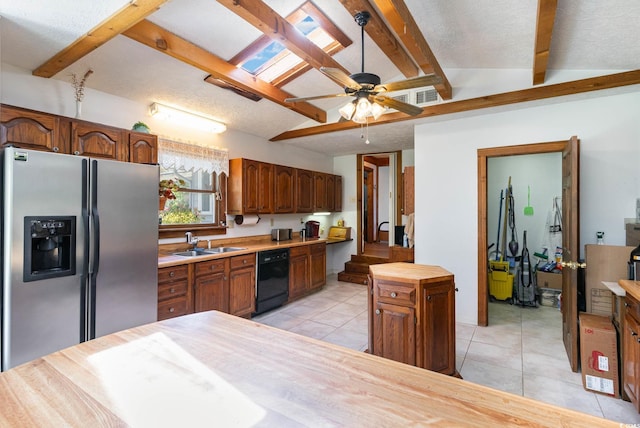 kitchen featuring stainless steel fridge, dishwasher, a sink, light tile patterned floors, and beamed ceiling