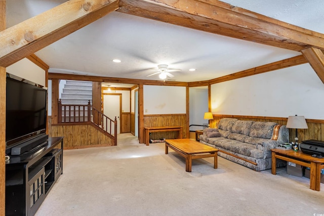 carpeted living room with wood walls, stairs, ceiling fan, wainscoting, and recessed lighting