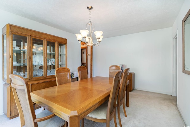 dining area with a chandelier and light colored carpet