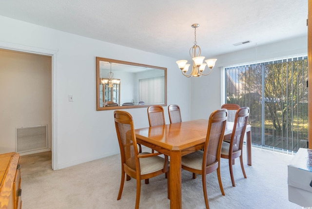 dining room featuring a chandelier, light colored carpet, and baseboards