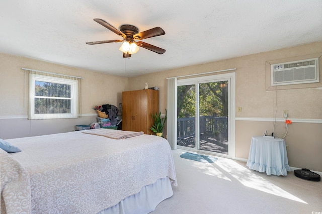 bedroom with access to outside, a wall mounted AC, carpet, and a ceiling fan